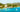 Boats docked along the turquoise coast of Martinique with lush hills in the background.