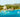 Boats docked along the turquoise coast of Martinique with lush hills in the background.